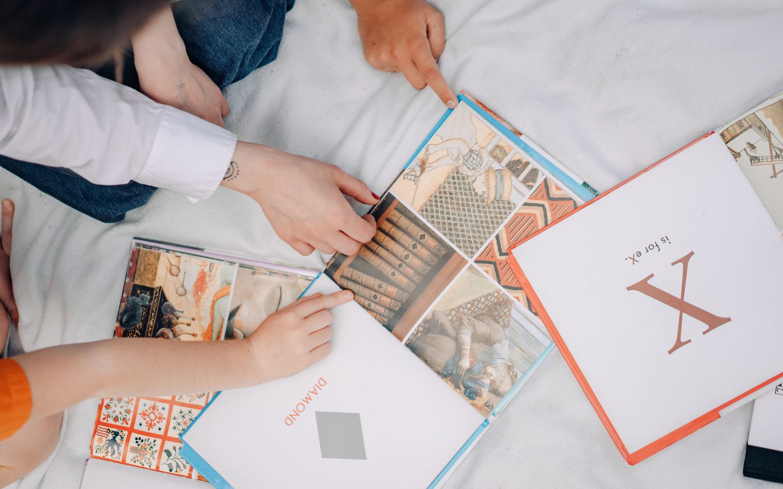 Kinderhände blättern gemeinsam in Bilderbüchern